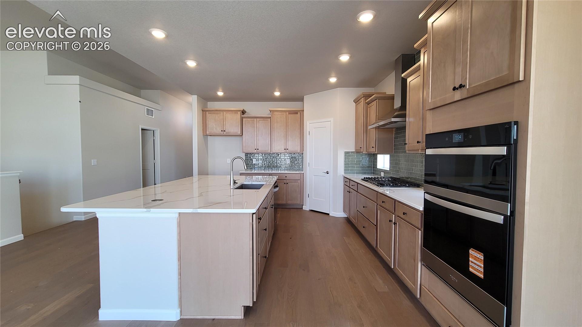 Gourmet Kitchen with quartz countertops, pantry, huge island providing additional seating, stainless steel gas cooktop, combo built-in microwave and oven, pyramid hood, and dishwasher! 