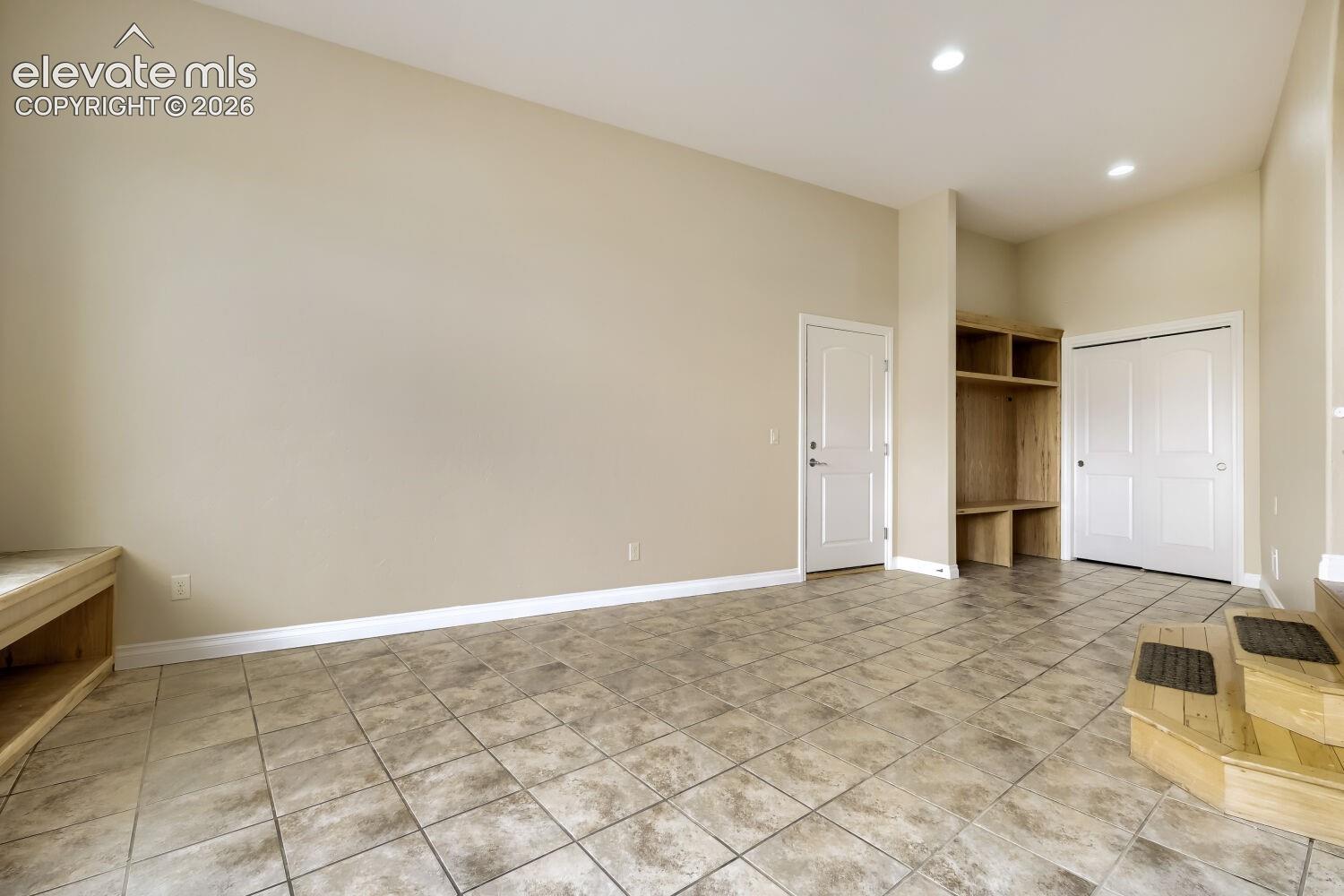 This mud room features built in cabinets, bench seating with Pikes Peak Views, a closet and a large locking dog door leading your pets to a fenced dog run.