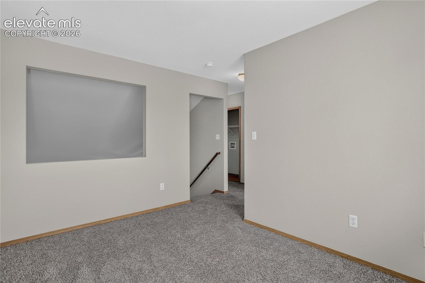 Gray carpeting, light-toned walls, and wood-finish trim