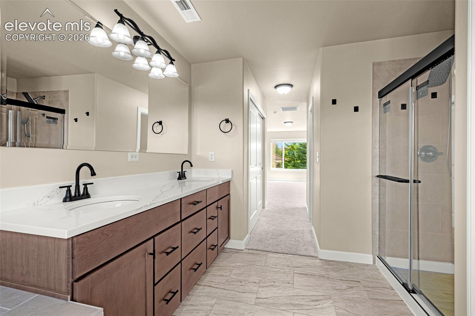 Another view of the Primary Bathroom.  Oversized walk-in shower, dual sinks with ample storage and His and Hers closets; one walk-in.  