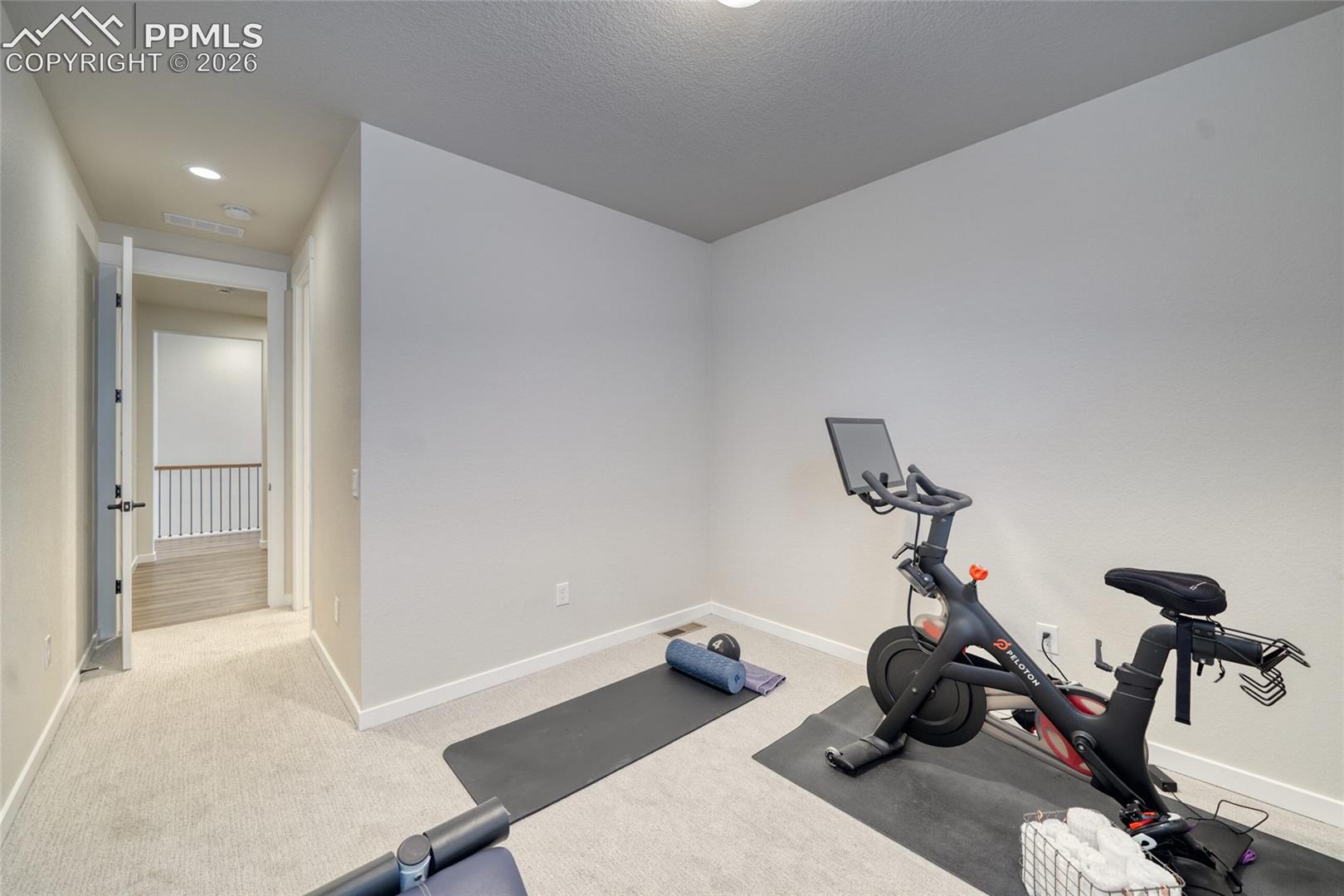 Workout area with light carpet and recessed lighting
