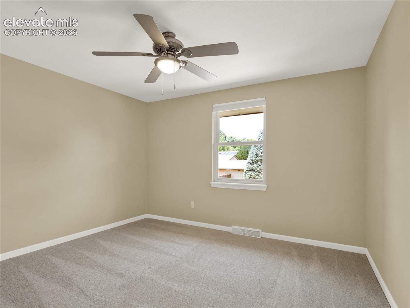 Neutral wall color, wall-to-wall carpeting, single-hung window, and a central ceiling fan with an integrated light fixture
