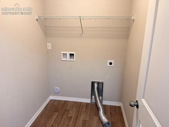 Dedicated utility space featuring wood-finish flooring, light neutral wall tones, and a wall-mounted wire shelving unit
