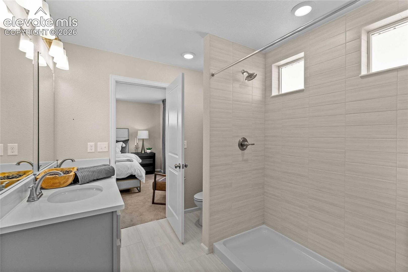 Dual sink vanity with white countertop, chrome fixtures, and overhead lighting
*photos of a model home*