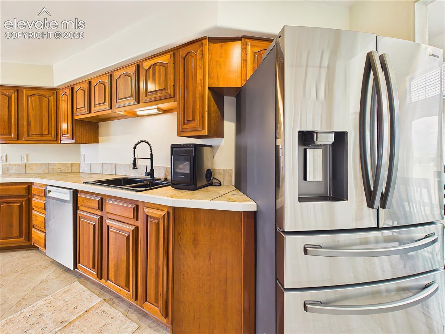 Stainless steel appliances, durable surfaces, and generous cabinetry combine style and practicality in this spacious culinary workspace.