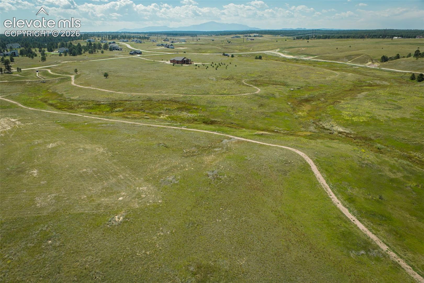 Expansive acreage featuring rolling prairie terrain, natural surface trails, and a mountainous horizon