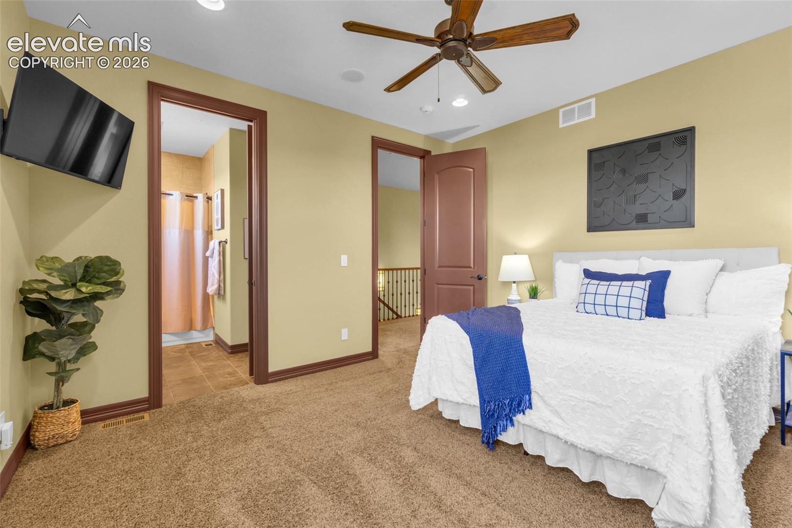 Carpeted bedroom featuring a wood-finish ceiling fan, recessed lighting, and arched interior doors with stained wood trim