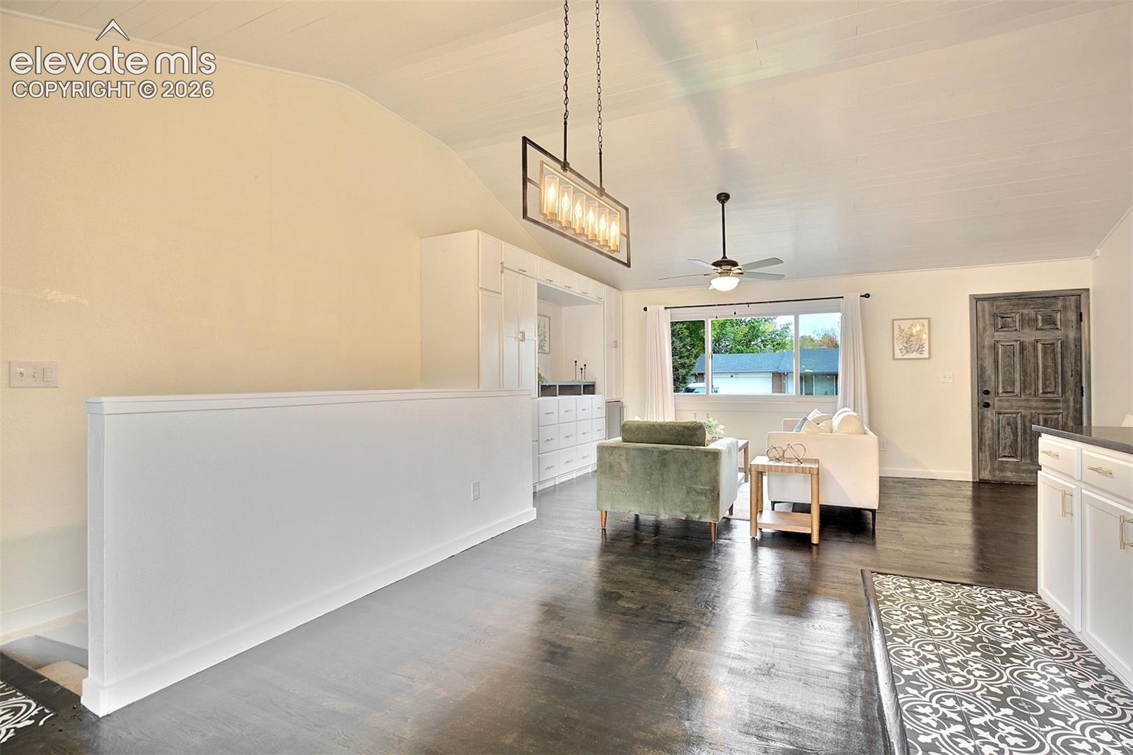Vaulted ceilings with tongue-and-groove paneling, dark wood-finish flooring, built-in cabinetry, rectangular pendant lighting, and patterned floor tile inlay