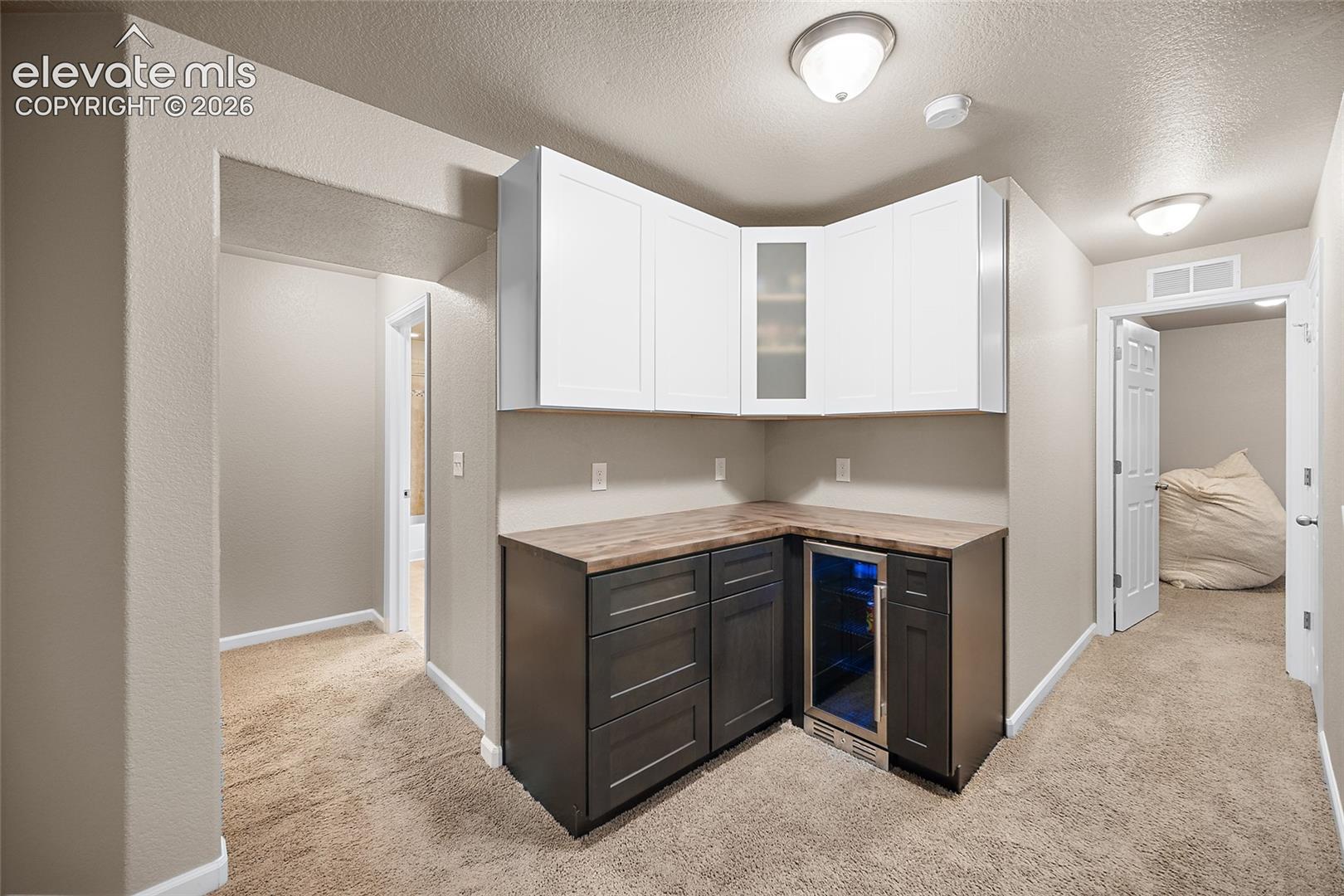 Custom basement dry bar with dedicated cabinetry and counter space.