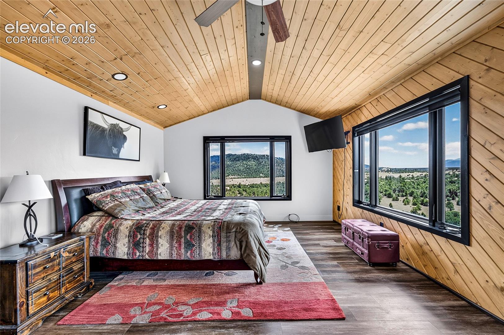 Vaulted wood-paneled ceiling with recessed lighting, wood-finish flooring, and large windows
