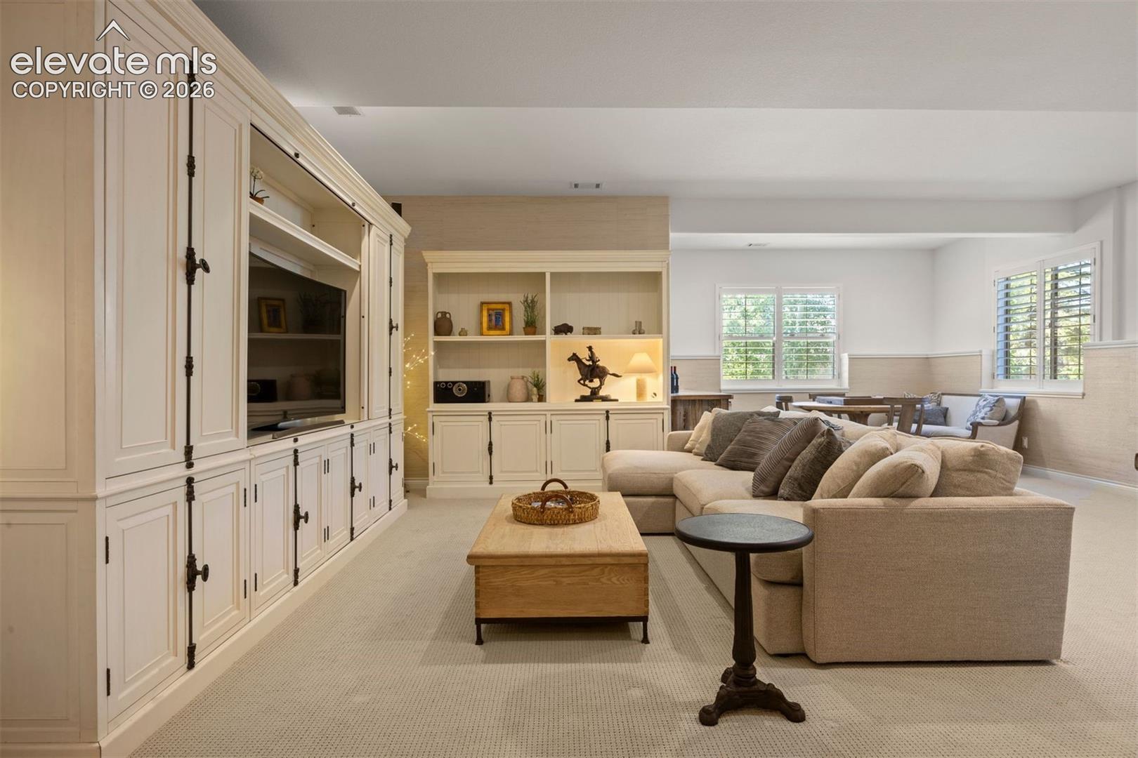 Expansive living area featuring extensive built-in cabinetry, recessed lighting, and carpeted flooring