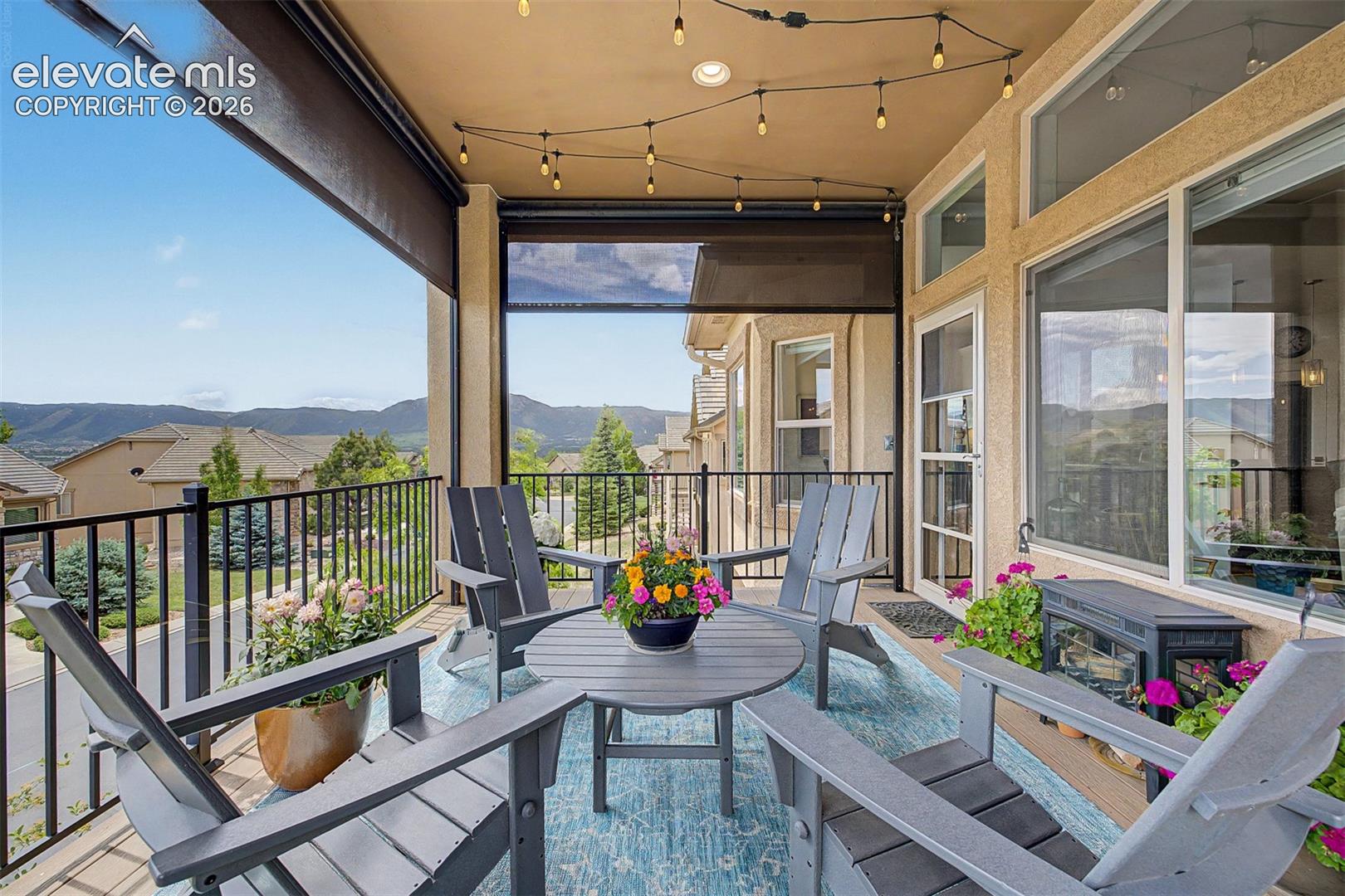 Large, covered patio off the living room & dining area that has custom remote-control blinds with beautiful mountain views and lush trees that makes for a serene peaceful entertaining area!