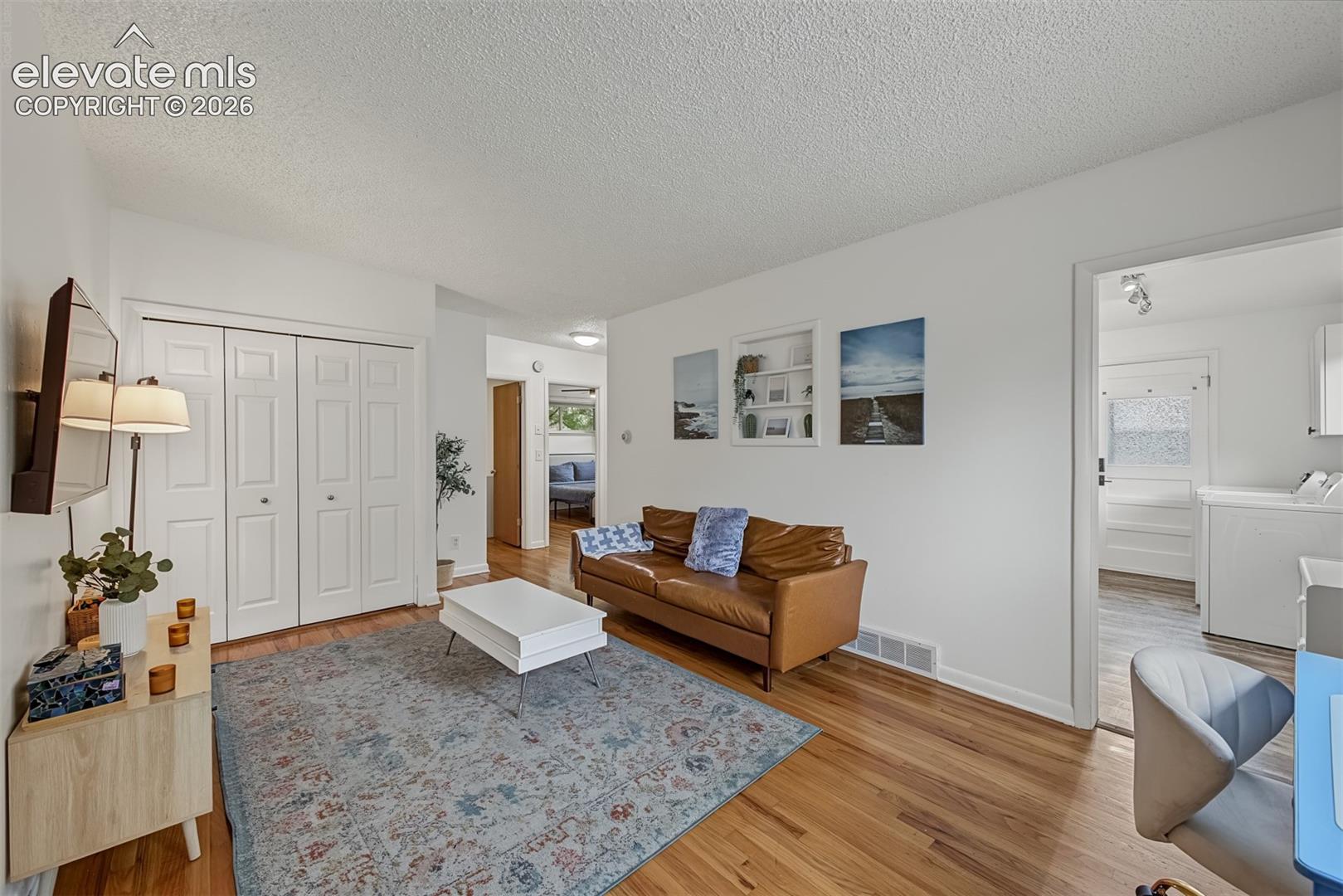 Wood-finish flooring, white walls, and bifold closet doors