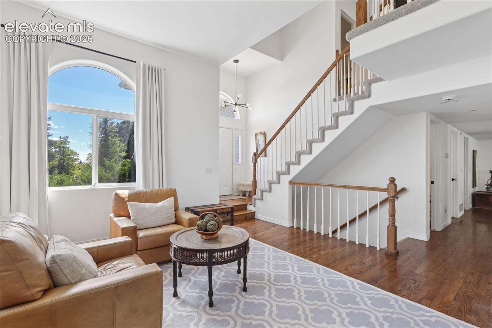 Formal living room with vaulted ceiling and hardwood floors