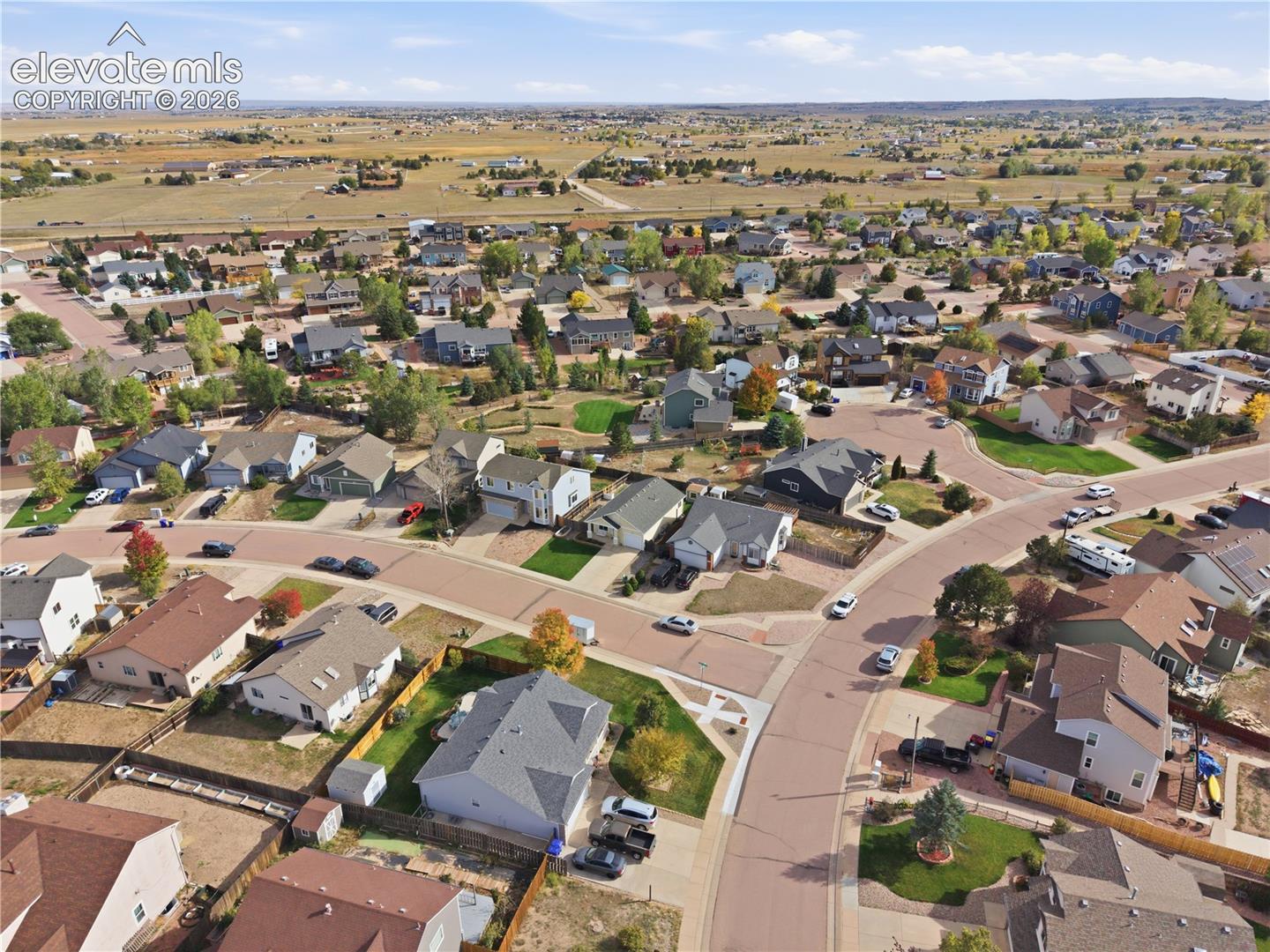 Residential development with paved roads, established homes, and surrounding open land