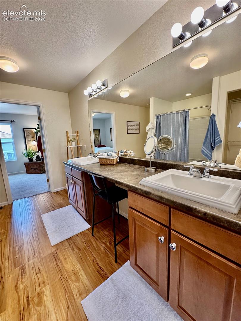 Dual vanity with integrated sinks and wood-finish flooring