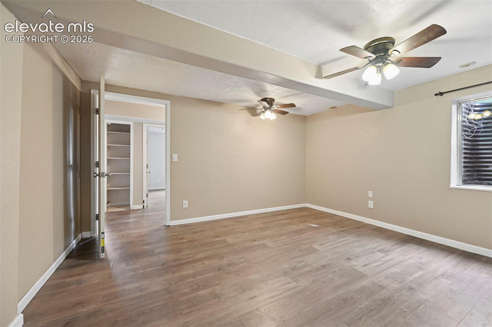 Spacious interior room featuring wood-finish flooring, neutral wall tones, and recessed lighting