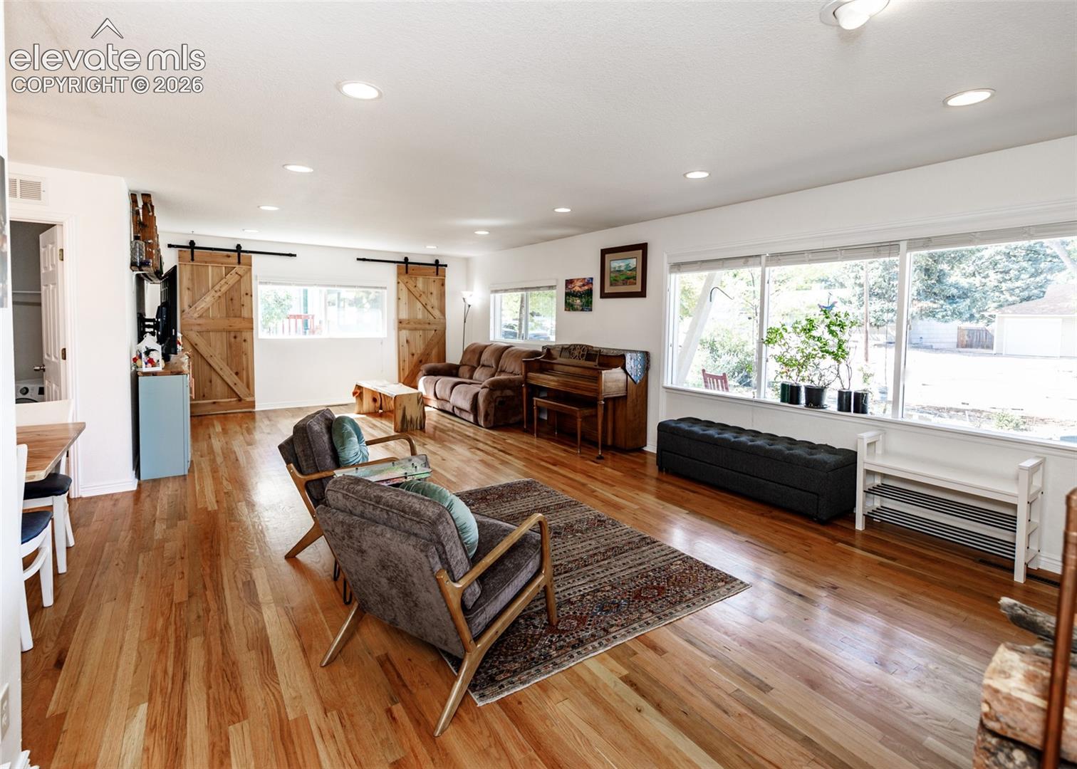 Hardwood flooring throughout, recessed lighting, and large windows