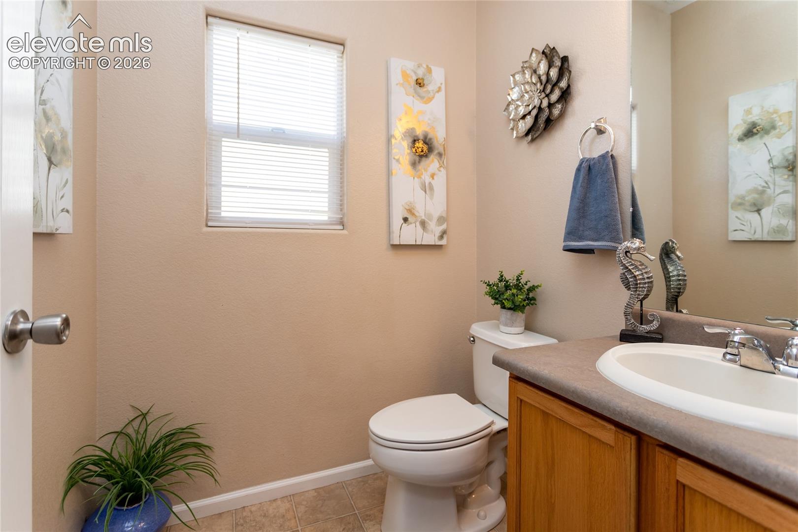 A conveniently placed lower-level half-bath serves guests and the family room area