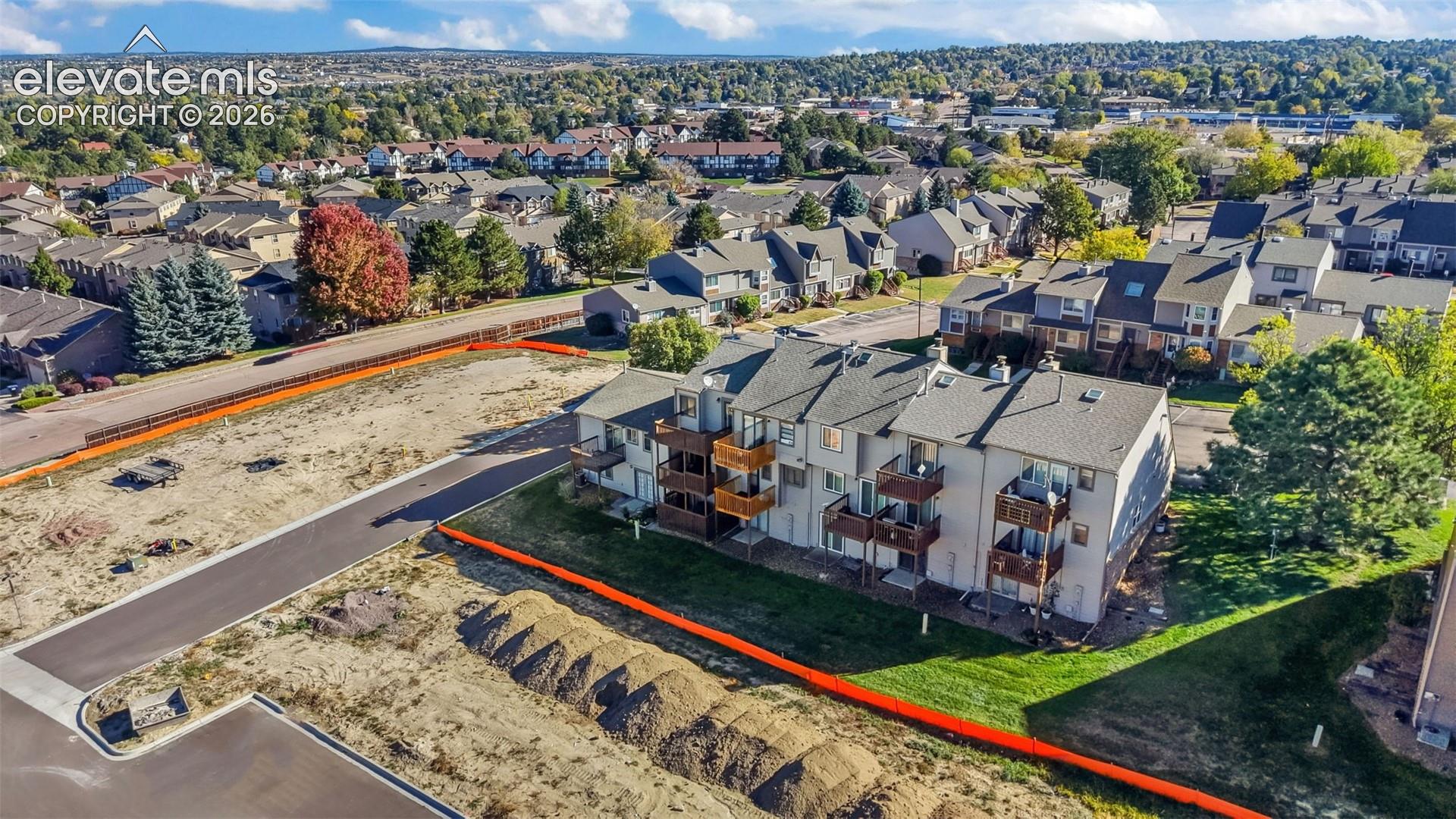 Multi-level residential building featuring wood-frame balconies, pitched shingle roofing, and exterior siding, situated within a suburban setting
