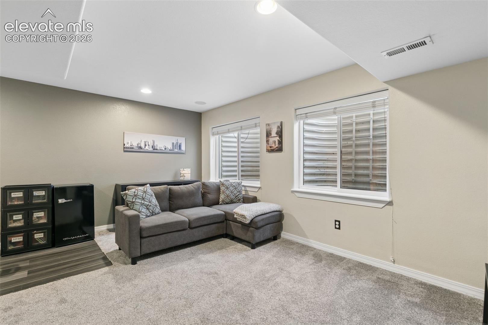 Plush carpet flooring, recessed lighting, and dual windows