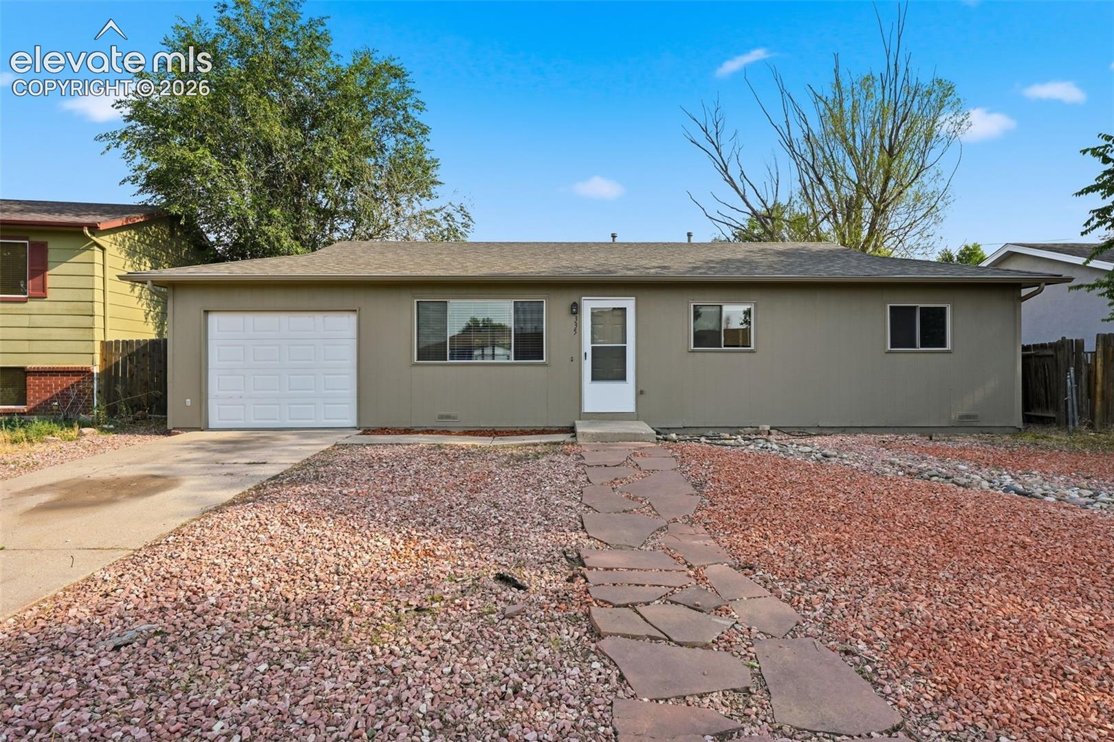 Single-story residence featuring a front entry, attached garage with white door, and a concrete driveway