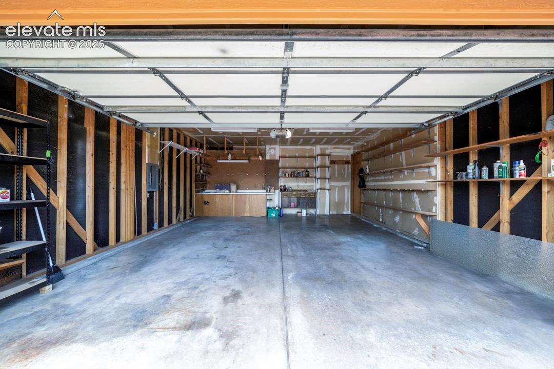 oversized garage with workbenches & shelving