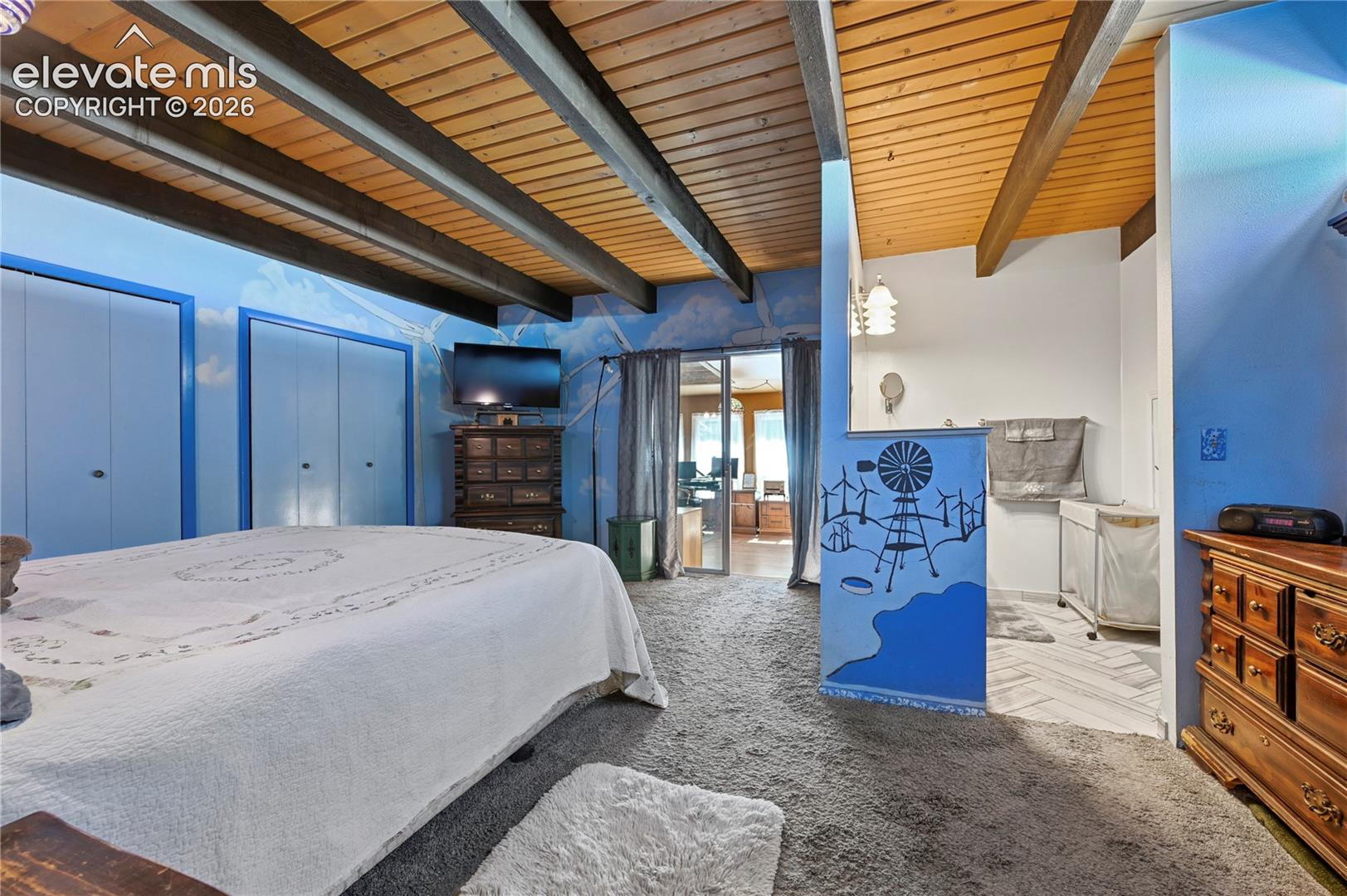 Main Bedroom, Exposed beam ceiling with wood paneling, sliding closet doors, and wood-finish flooring