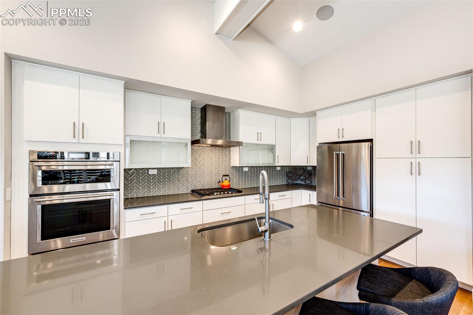 Custom glass front open cabinetry, Herringbone backsplash, and Gourmet Style Kitchen finishes add to the panache!