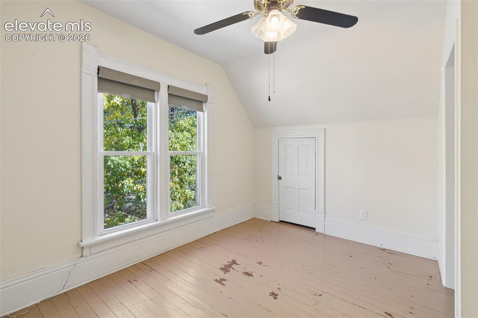 Bedroom #1 Vaulted ceilings, painted wood flooring, and oversized windows with decorative millwork framing