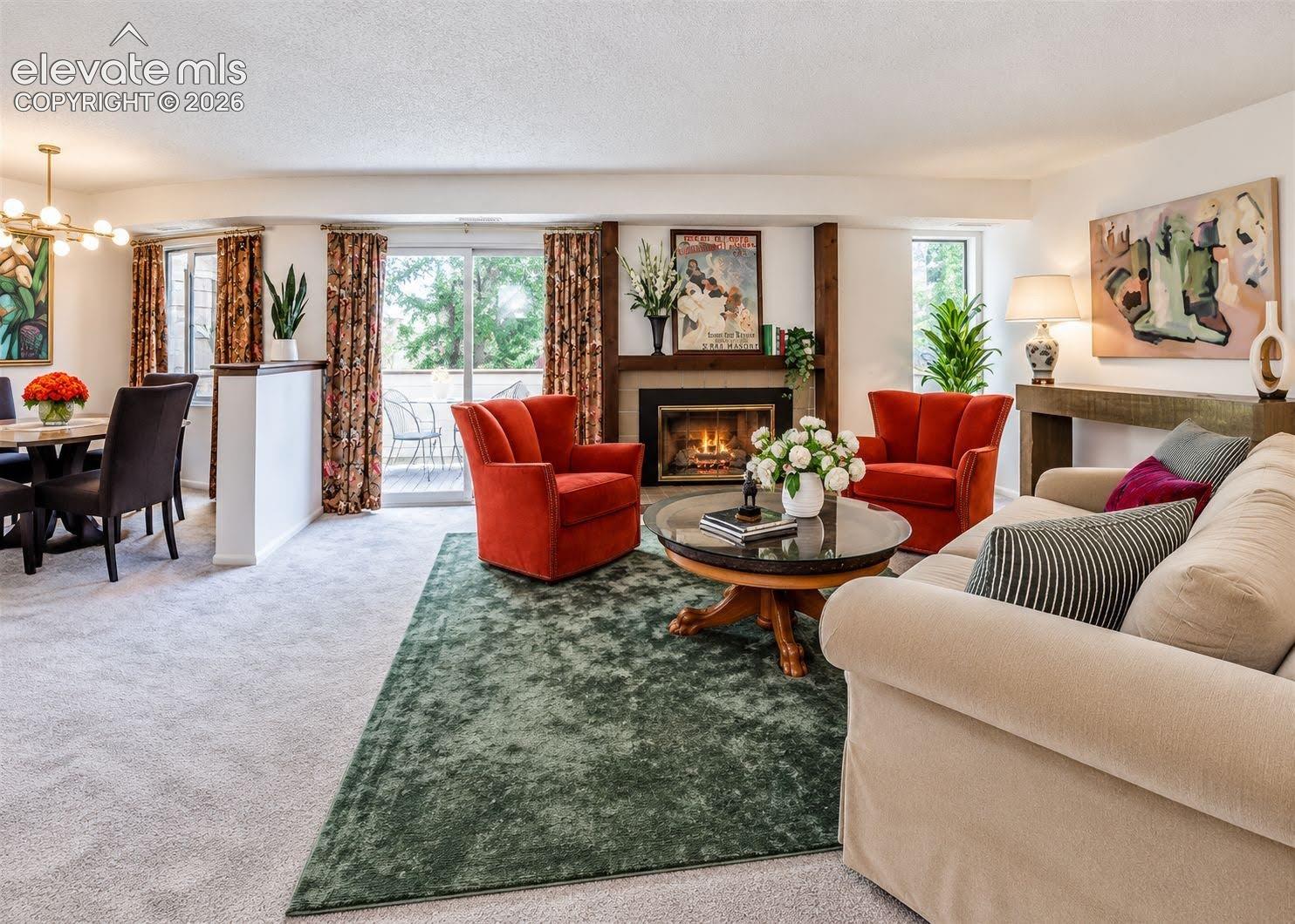 Living area featuring a fireplace with a wood mantel, sliding glass doors, and a ceiling-mounted light fixture