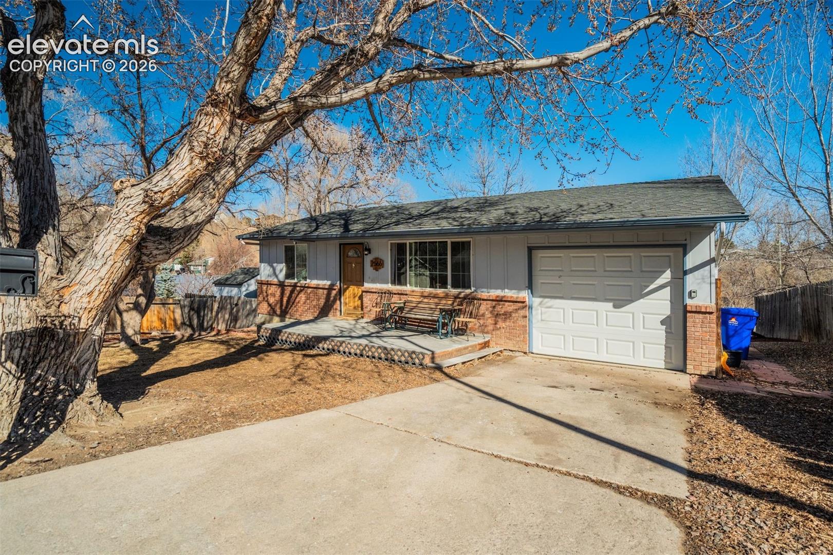 Single-story residence featuring a wood-panel front door, an attached garage, and a concrete driveway
