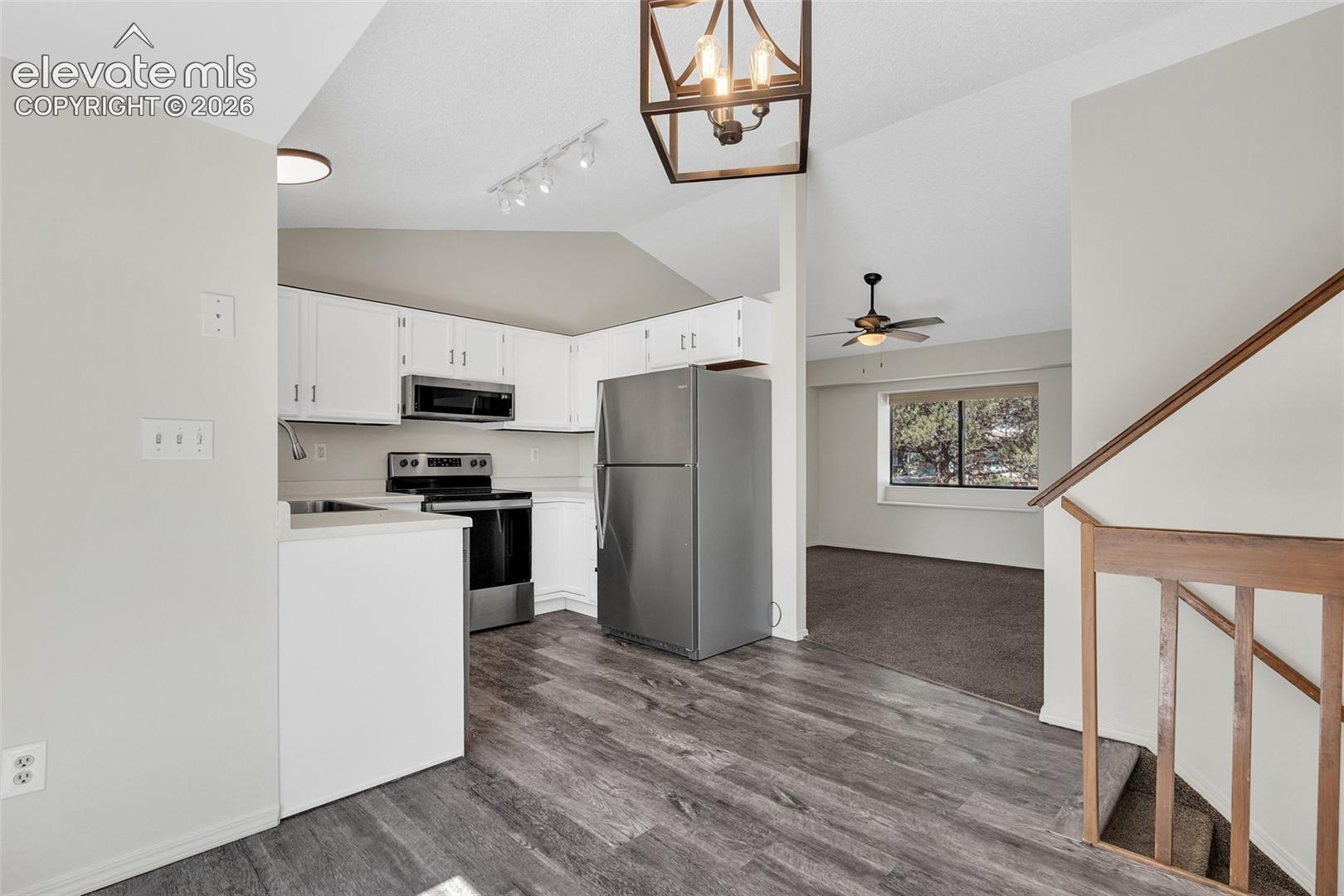 Kitchen with white cabinetry, stainless steel appliances, and luxury vinyl plank