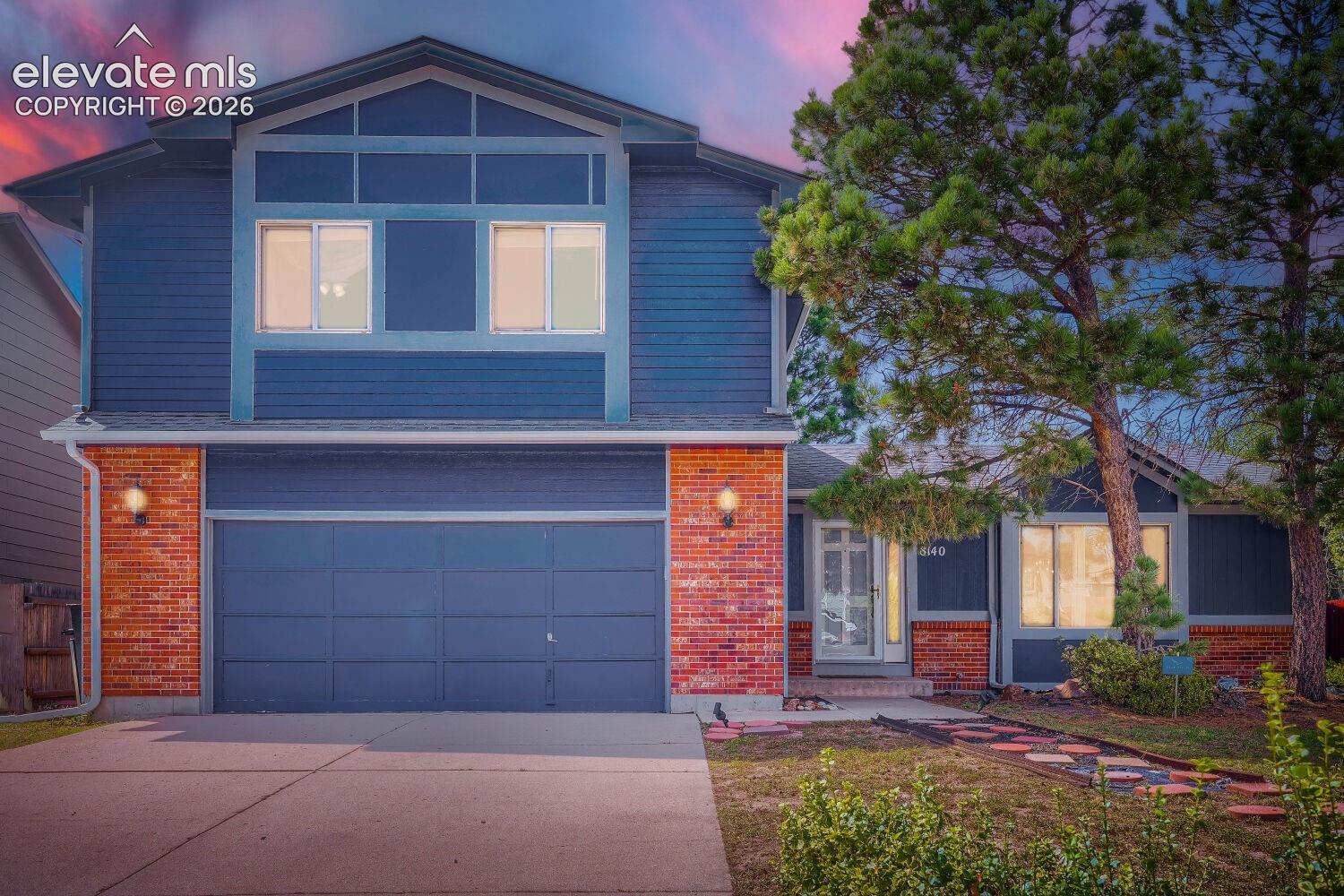 Two-story exterior with blue siding and brick accents