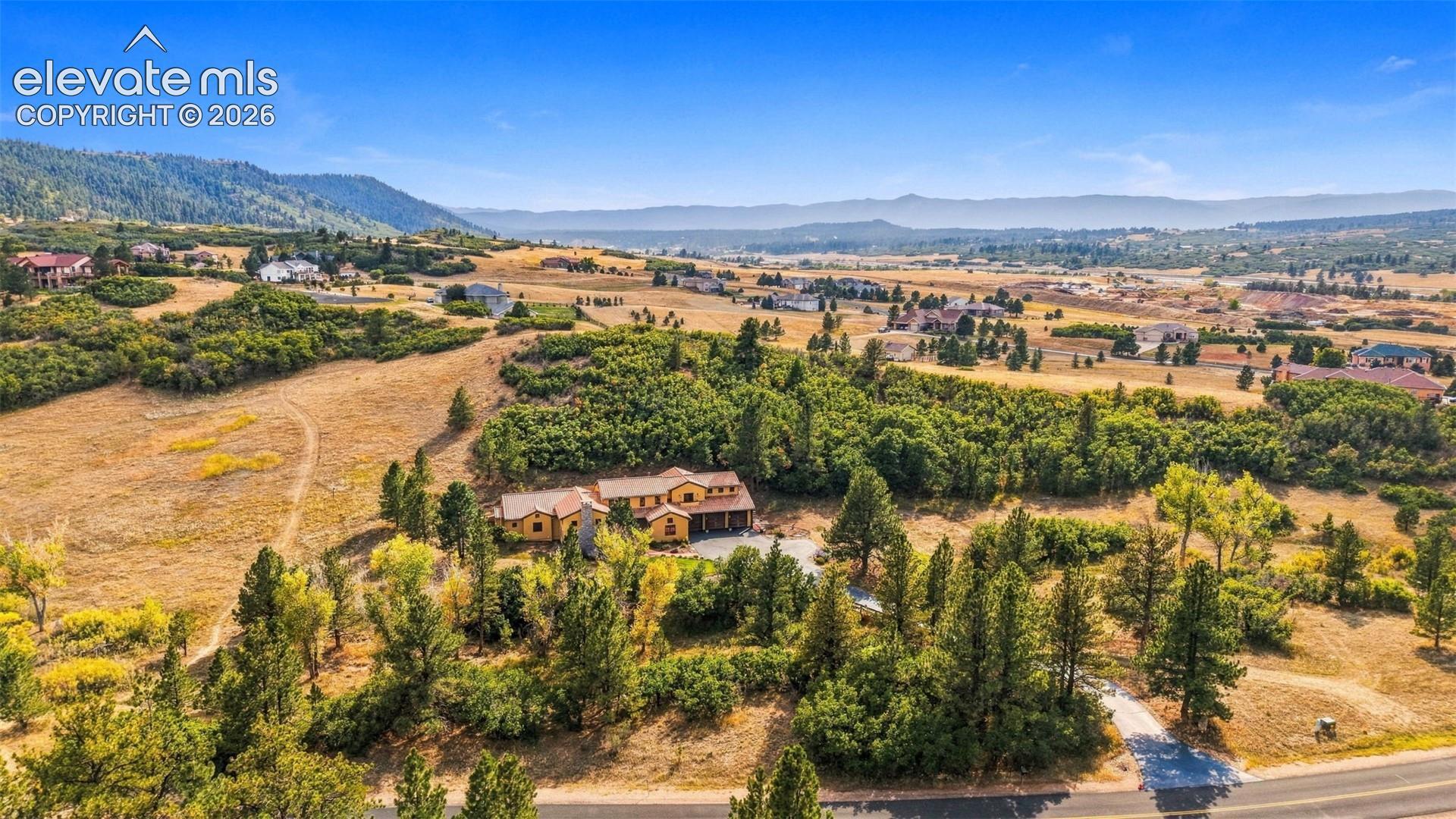 Expansive property with a multi-level residence, attached garages, and a paved driveway