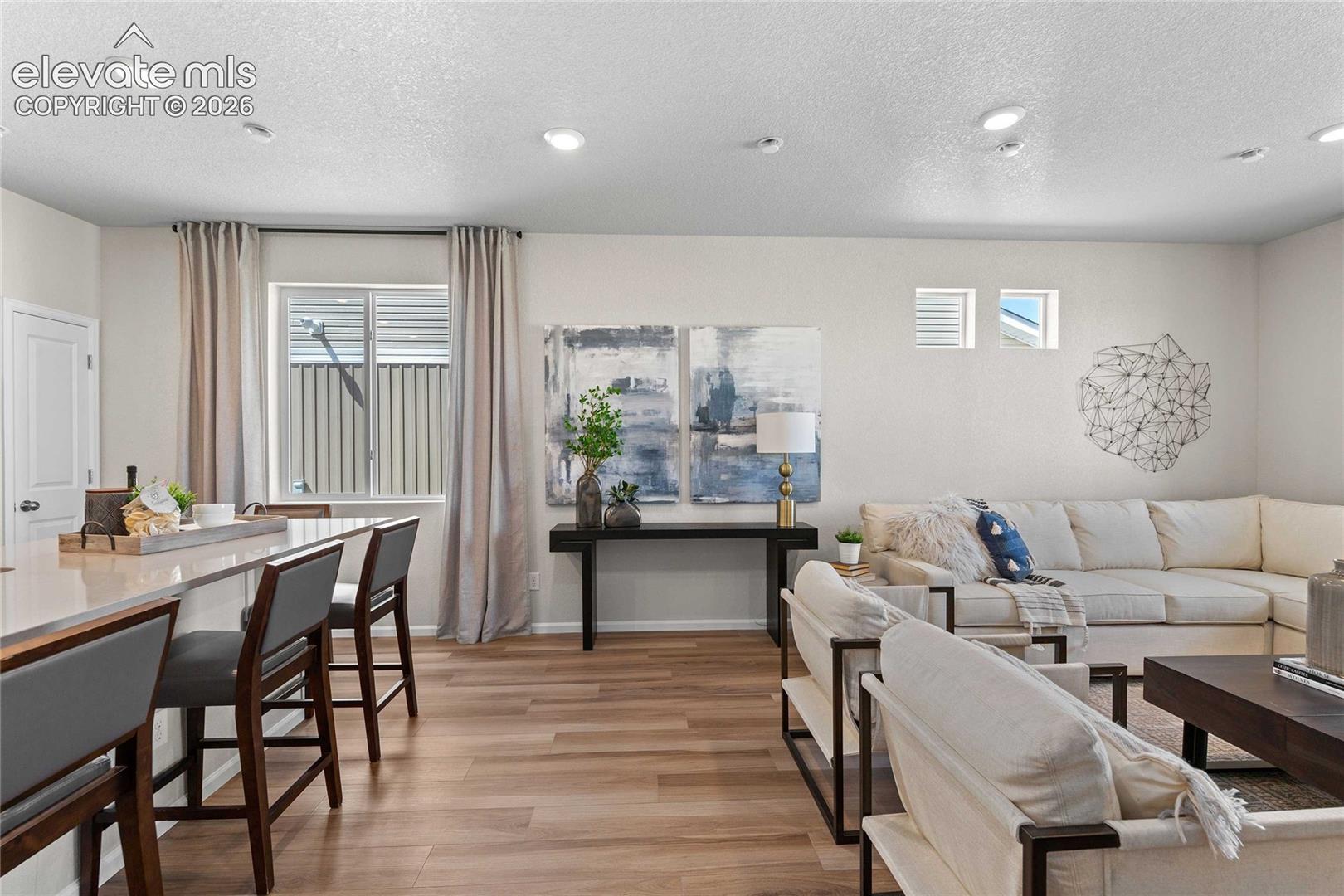 Recessed lighting illuminates the open-concept living space with wood-finish flooring
*photos of a model home*