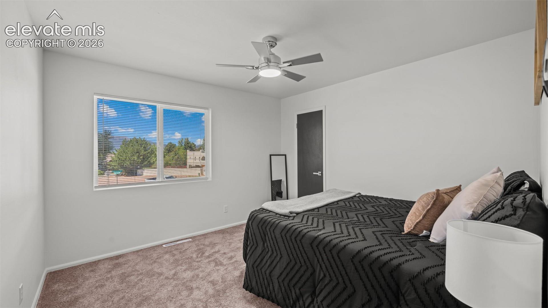 Carpeted flooring, contemporary ceiling fan with integrated lighting, and a window with horizontal blinds