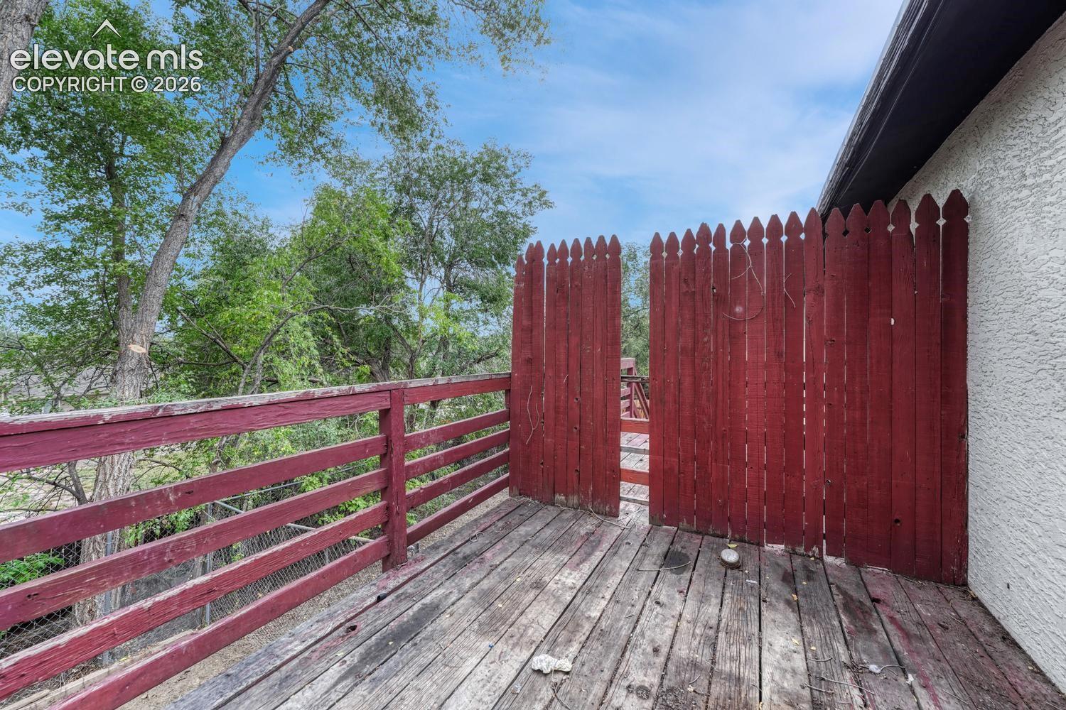 Exterior deck with wood flooring and red-painted wooden railing