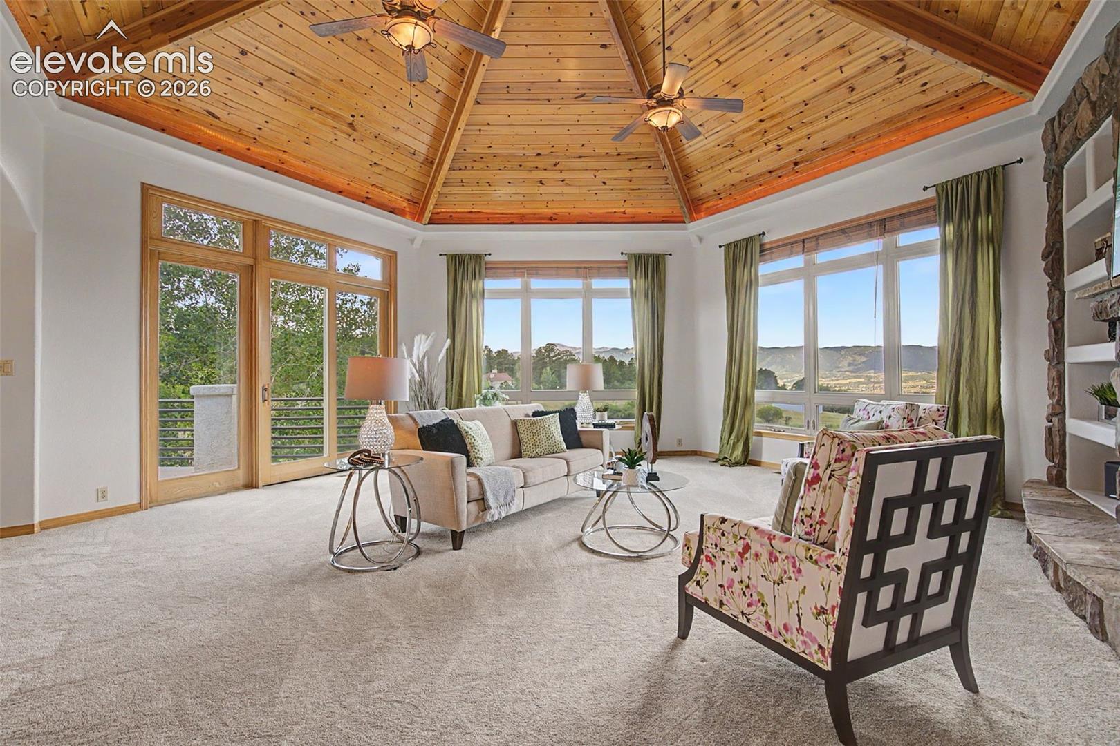 Vaulted wood-paneled ceiling with recessed lighting and ceiling fans