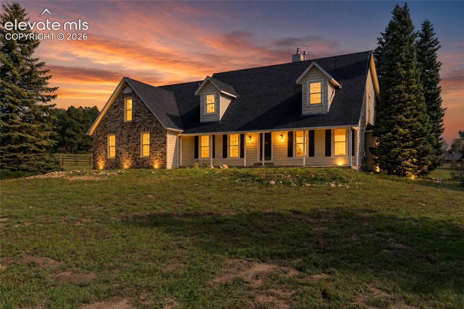 Crafted home exterior featuring brick and siding finishes, a dark shingle roof, dormer windows, and a covered front porch