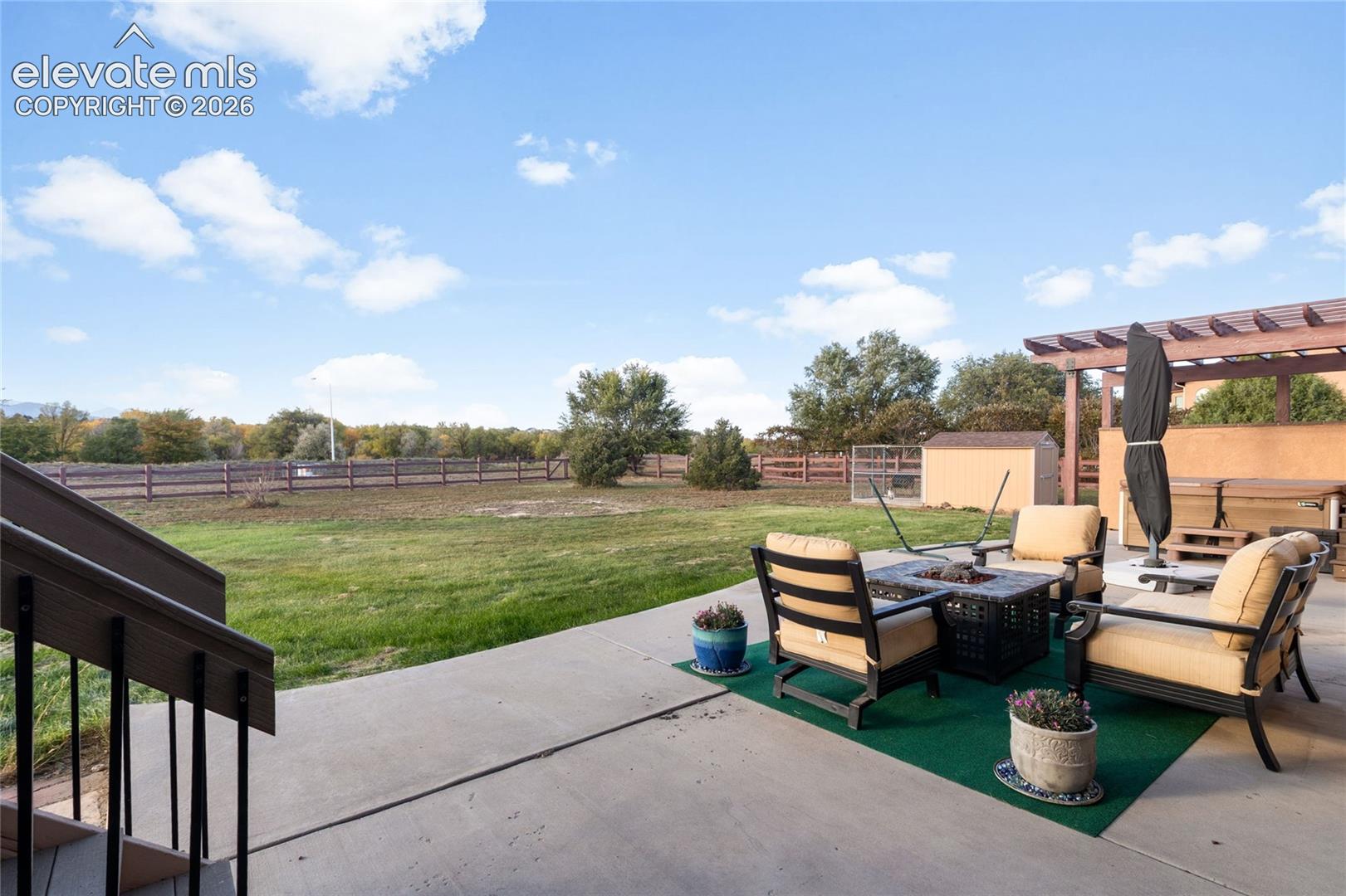 Patio for all the backyard entertaining and games, large hot tub with pergola, views of Pikes Peak to the left