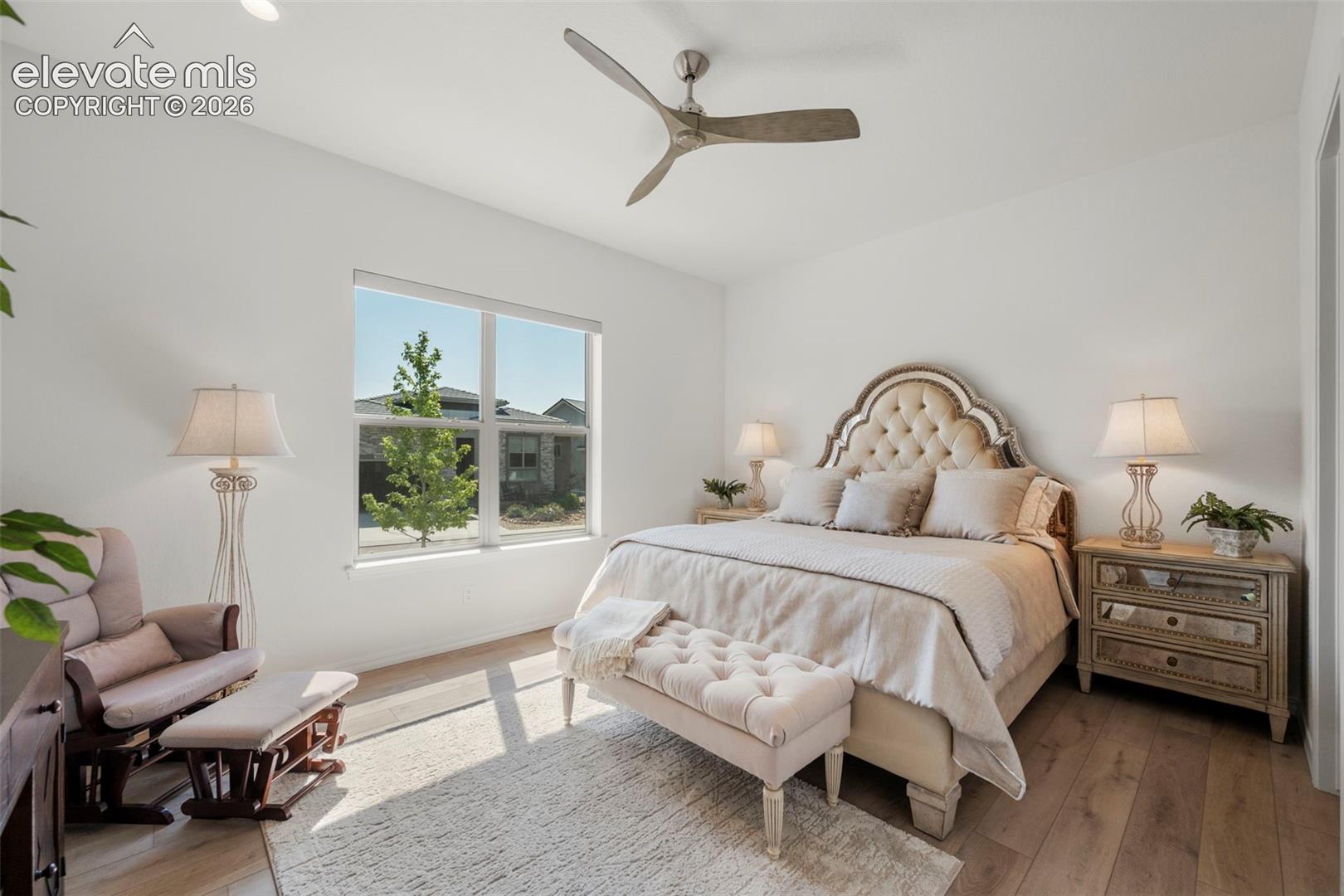 Bright interior with beautiful flooring, a contemporary ceiling fan, and a large window
