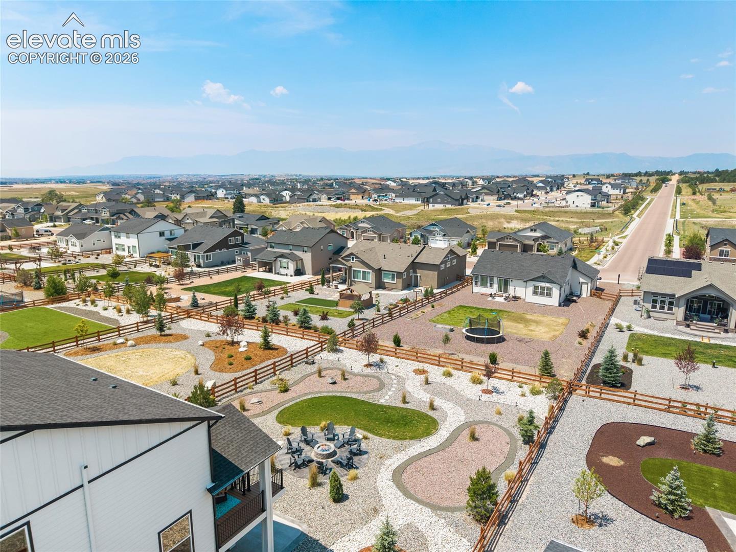 Expansive landscaped property featuring a large patio, fire pit area, and mature plantings