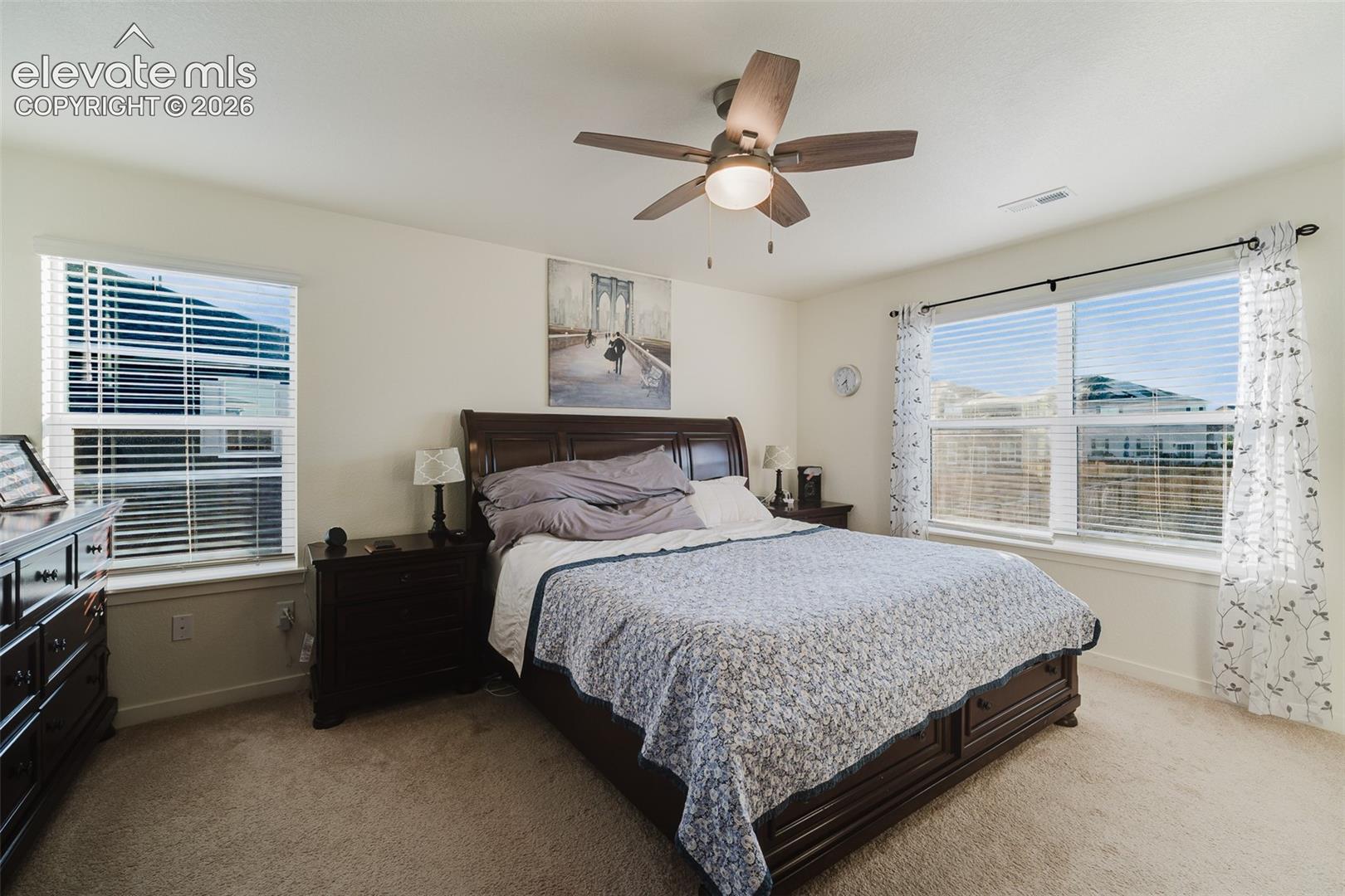 The Primary Bedroom is a private retreat featuring neutral carpet, a lighted ceiling fan, walk in closet, and adjoining Shower Bathroom.