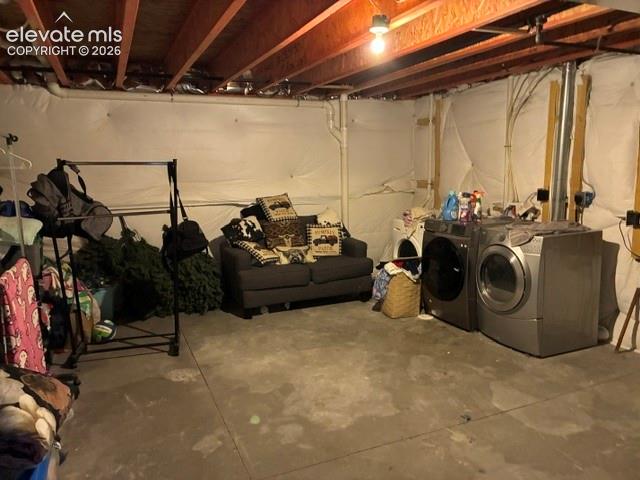 Unfinished basement area featuring exposed ceiling joists, concrete flooring, and perimeter insulation wrap