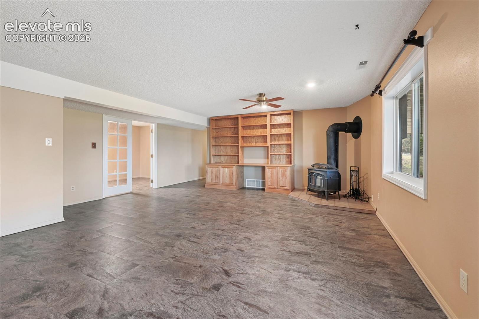 Downstairs living area with built-in wood bookcase, and a wood-burning stove.