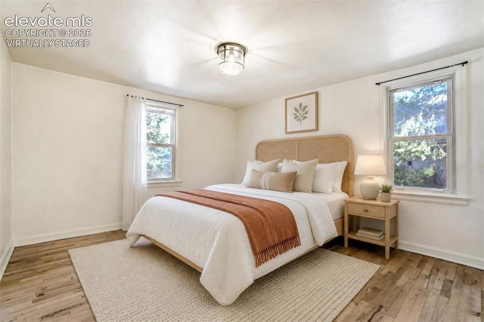 Virtually Staged  Wood-finish flooring, dual windows providing natural light, and a central flush-mount ceiling fixture
