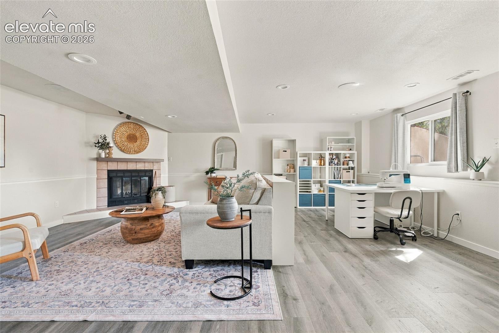 Basement Corner fireplace with a tile surround and hearth