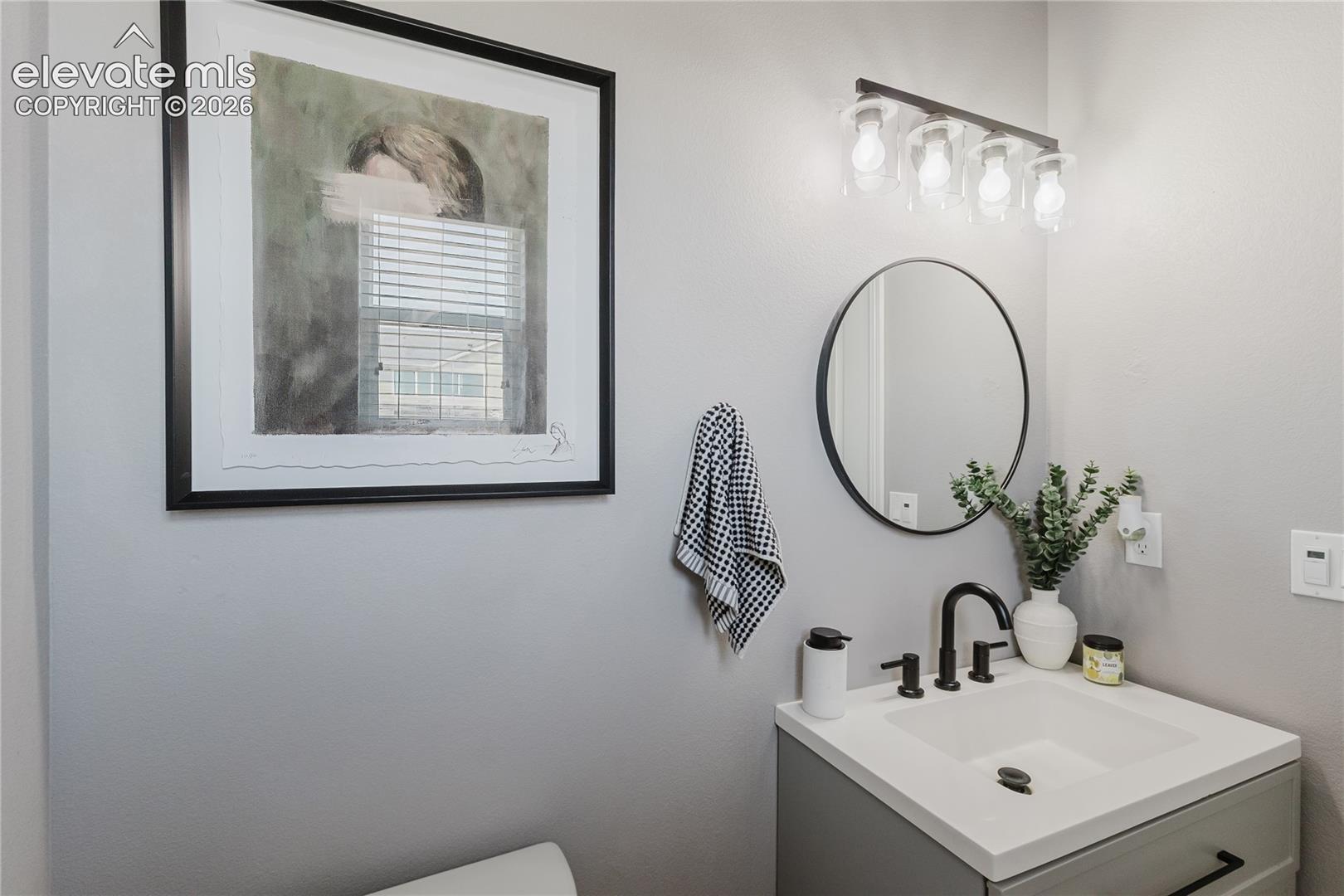 Vanity featuring a rectangular undermount sink, light countertop, and matte black faucet