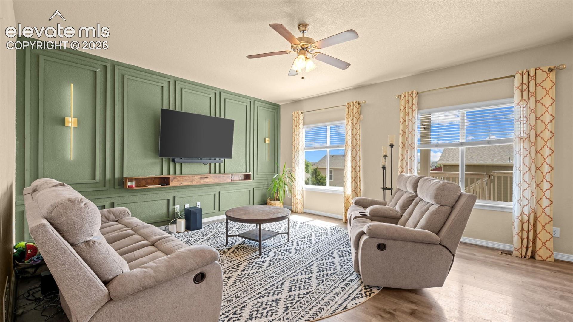 Living room with a feature wall showcasing vertical paneling, integrated sconces, and a floating wood-finish media shelf